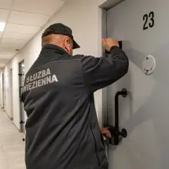 Wychowawca w więzieniu przy drzwiach celi nr 23. Zastanawiasz się, ile zarabia wychowawca w więzieniu?