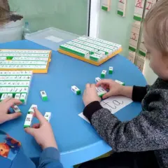 Dzieci uczą się liter i słów za pomocą klocków. To przykład glottodydaktyki, która pokazuje, jak łatwo można zacząć naukę czytania.