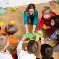 Nauczycielka przedszkola z dziećmi tworzy kolorową mozaikę. Każdy element to mały sukces, ale czasem coś nie pasuje, jak w życiu.