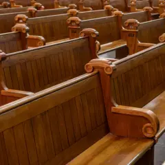 Puste, drewniane ławki w kościele, symbolizujące rezygnację z religii i pustkę po odejściu wiary.
