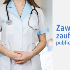Osoba zaufania publicznego w białym fartuchu z niebieskimi wykończeniami i stetoskopem.