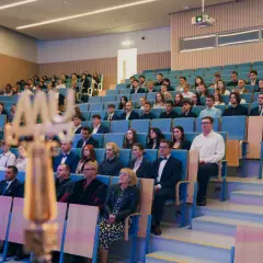 Uroczystość wręczenia dyplomów. Młodzi ludzie zastanawiają się, co po studiach medycznych, siedząc w auli.