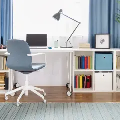 Biurko z laptopem i krzesłem, idealne do edukacji domowej w technikum. Półki pełne książek i materiałów do nauki.