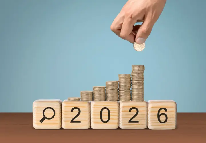 Klocki z napisem "2026" i lupą, na nich rosnące stosy monet. Czy to podpowiedź, ile zarabia nauczyciel mianowany w przedszkolu?