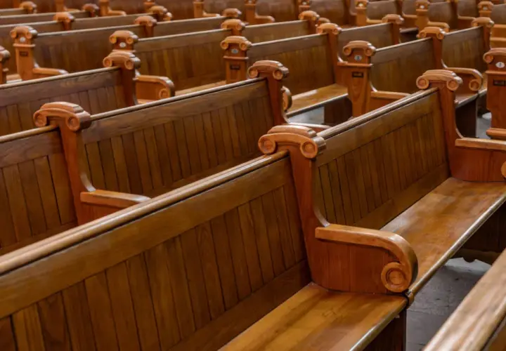 Puste, drewniane ławki w kościele, symbolizujące rezygnację z religii i pustkę po odejściu wiary.