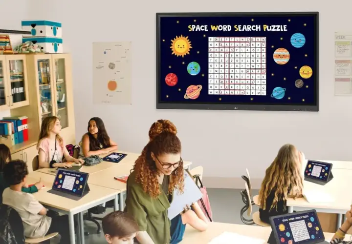 Nowoczesna klasa szkolna z uczniami rozwiązującymi kosmiczną łamigłówkę na tabletach i interaktywnym ekranie.