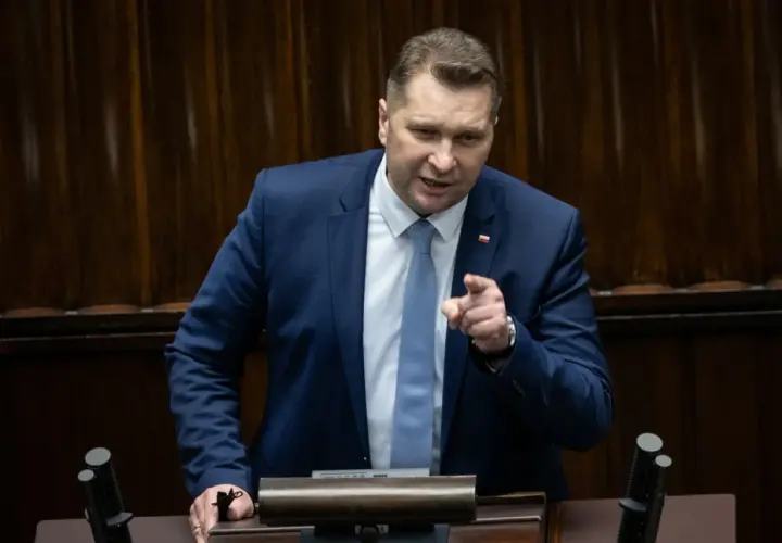 Mężczyzna w garniturze przemawia, wskazując palcem. Dyskusja dotyczy ustawy Lex Czarnek.