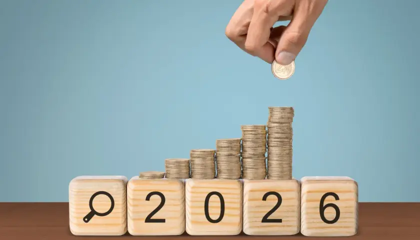 Klocki z napisem "2026" i lupą, na nich rosnące stosy monet. Czy to podpowiedź, ile zarabia nauczyciel mianowany w przedszkolu?
