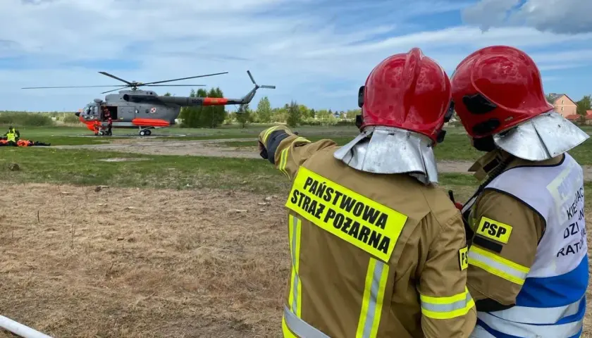 Strażacy w akcji przy śmigłowcu. Zastanawiasz się, ile zarabia strażak po szkole oficerskiej?