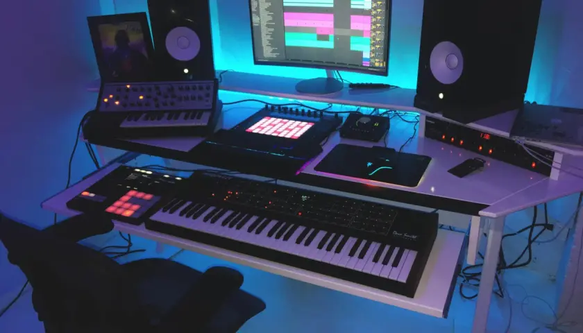 Nowoczesne studio muzyczne z syntezatorami, kontrolerami MIDI i komputerem, ukazujące zastosowanie komputerów w muzyce.