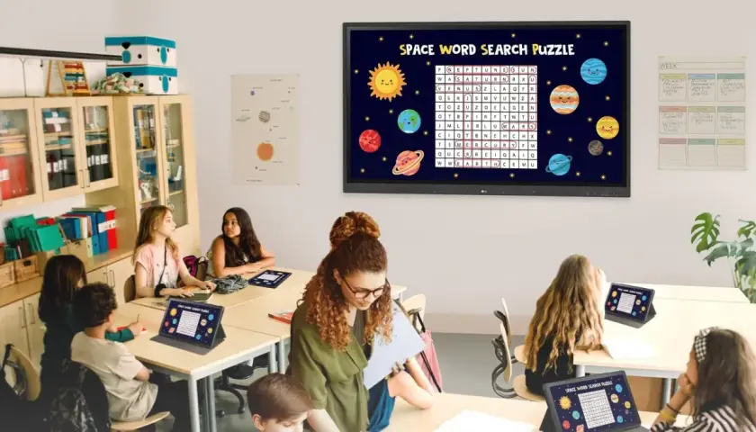 Nowoczesna klasa szkolna z uczniami rozwiązującymi kosmiczną łamigłówkę na tabletach i interaktywnym ekranie.
