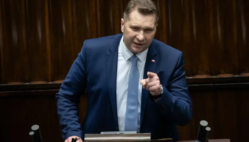 Mężczyzna w garniturze przemawia, wskazując palcem. Dyskusja dotyczy ustawy Lex Czarnek.