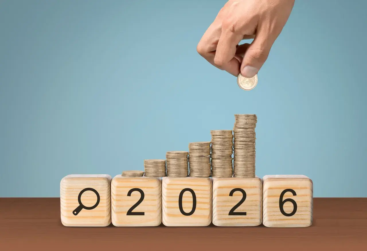 Klocki z napisem "2026" i lupą, na nich rosnące stosy monet. Czy to podpowiedź, ile zarabia nauczyciel mianowany w przedszkolu?