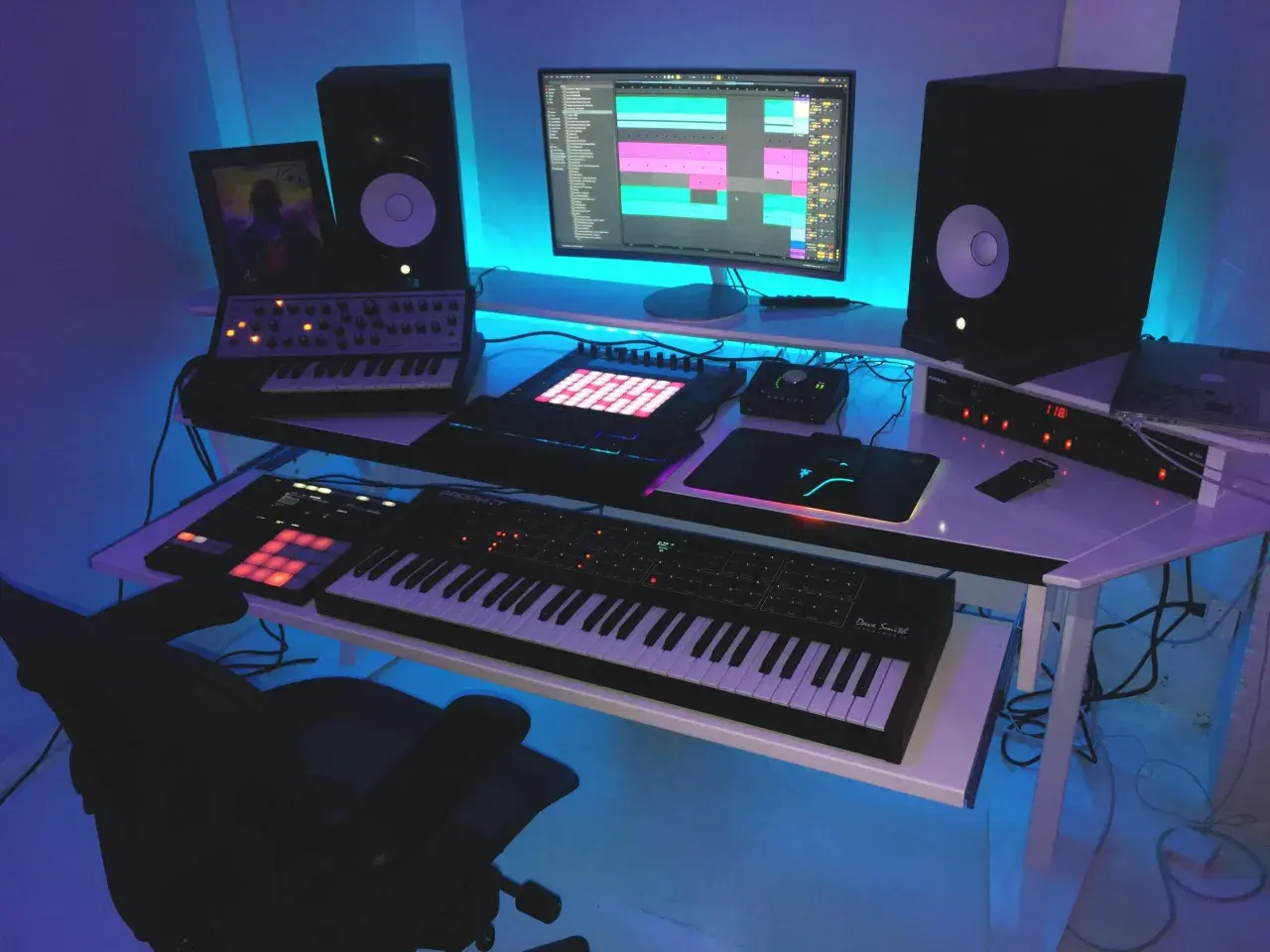Nowoczesne studio muzyczne z syntezatorami, kontrolerami MIDI i komputerem, ukazujące zastosowanie komputerów w muzyce.