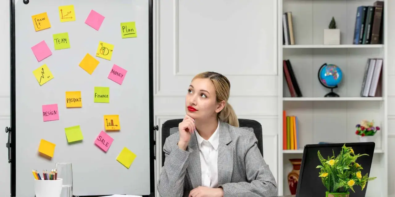 Młoda kobieta zastanawia się nad ścieżkami kariery po studiach marketing i zarządzanie, widząc na tablicy słowa kluczowe: plan, zespół, produkt, finanse, sprzedaż.
