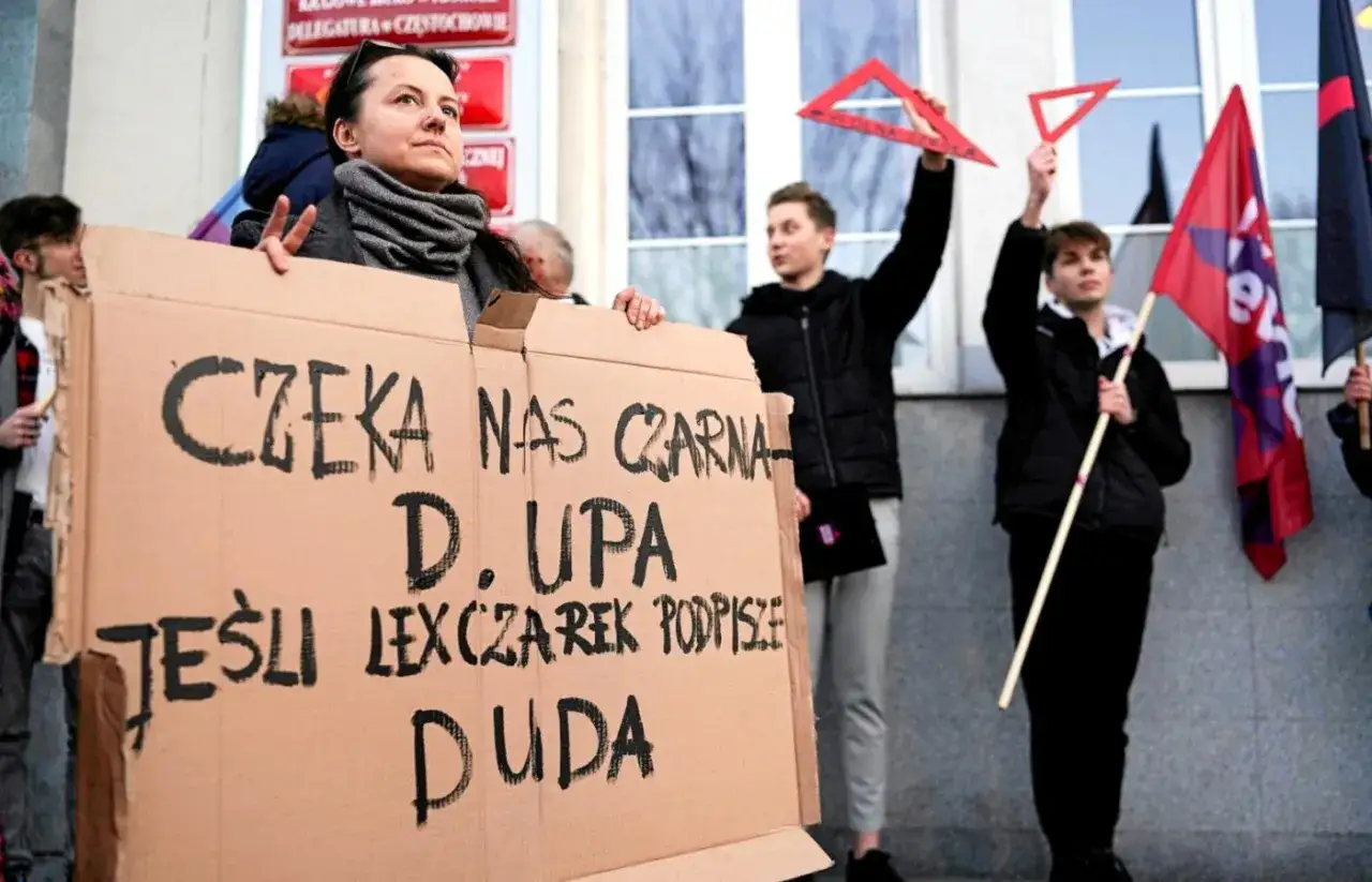 Protestujący trzymają transparent: 