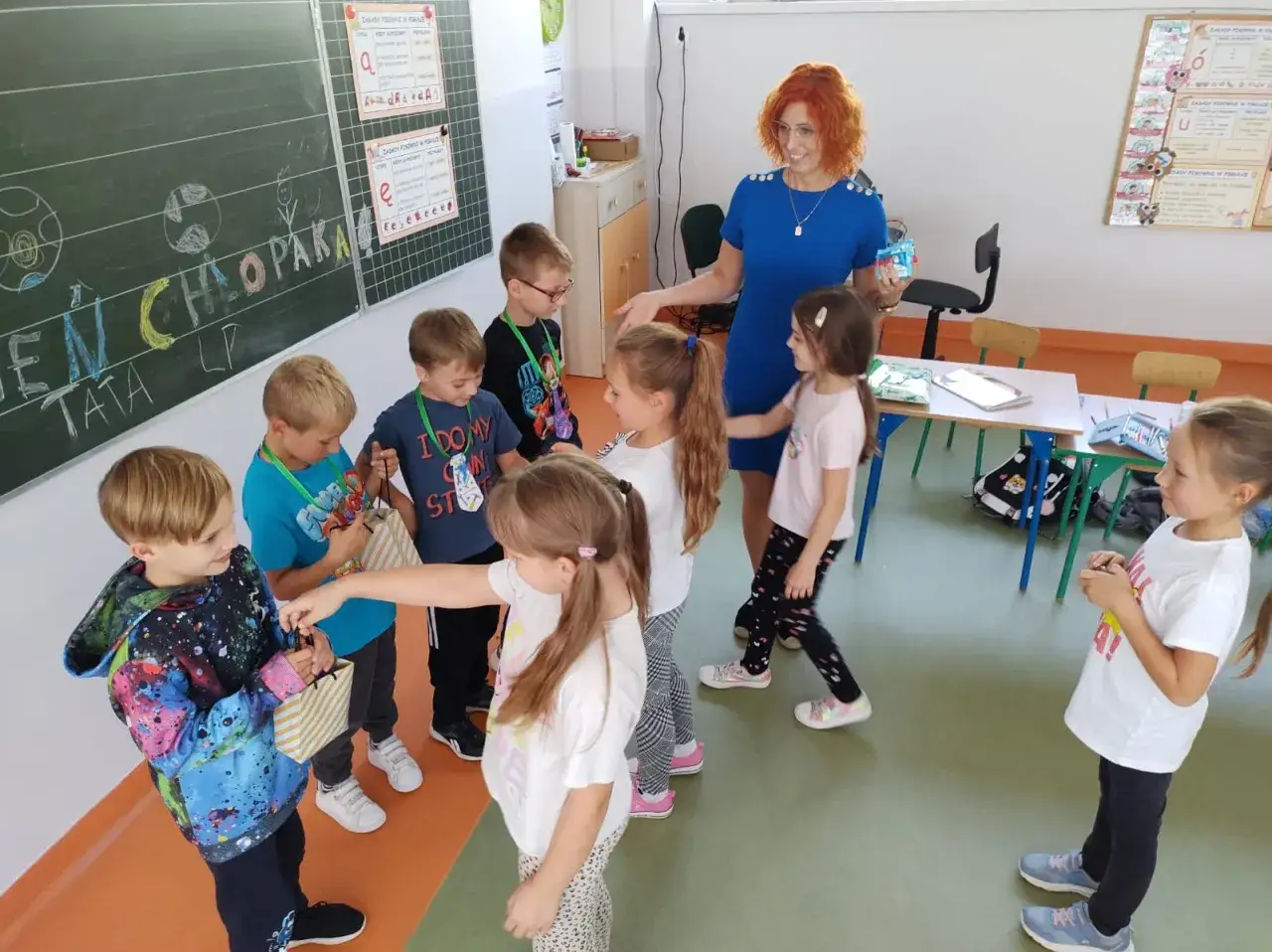 Nauczycielka przedszkola rozdaje prezenty, co jest jednym z wielu sukcesów w pracy. Dzieci cieszą się, choć czasem zdarzają się też trudniejsze momenty.