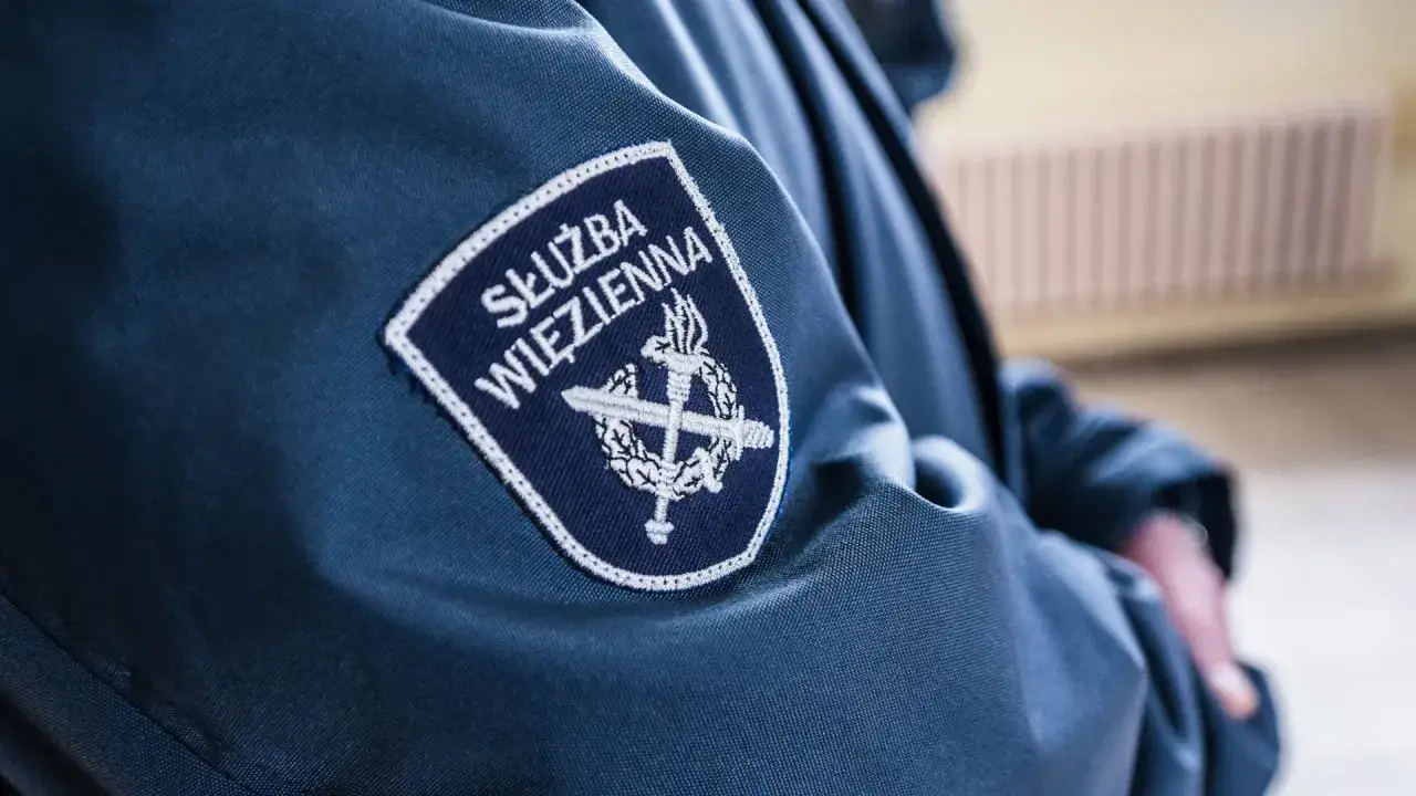 Emblemat Służby Więziennej na granatowej kurtce. Zastanawiasz się, ile zarabia wychowawca w więzieniu?