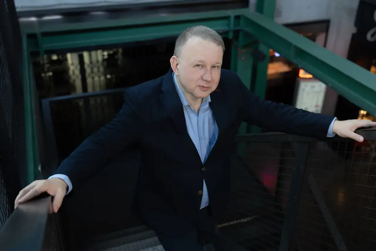 Mężczyzna w garniturze na schodach. Dziennikarstwo otwiera wiele drzwi, od pisania po zarządzanie mediami.
