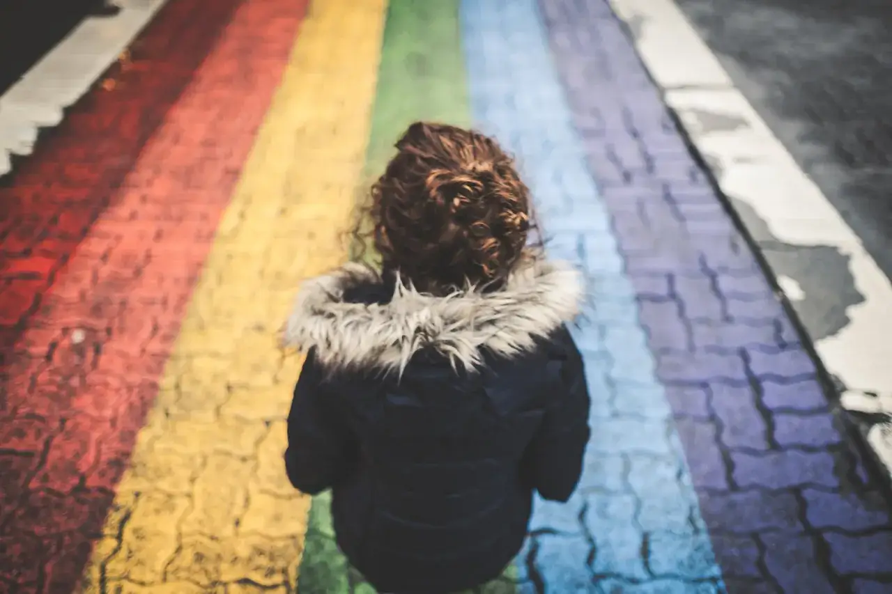 Dziecko na tęczowym przejściu dla pieszych symbolizuje nadzieję na akceptację i równość, w tym lgbt w szkołach.